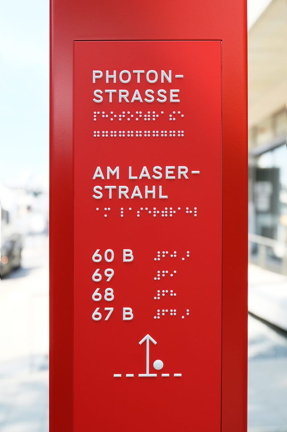 Directional pylon with wayshowing panel incl. raised graphics and braille